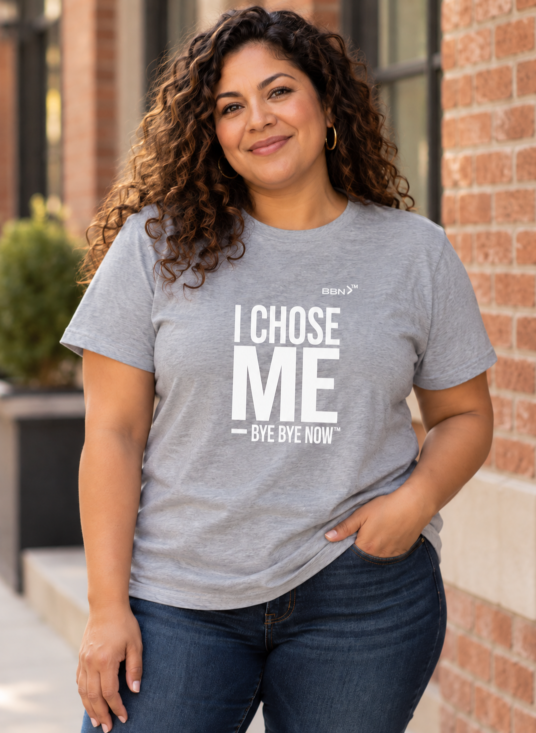 AI styling concept: Woman outdoors wearing an athletic heather gray T-shirt with bold white “I Chose Me” lettering and white “Bye Bye Now”.