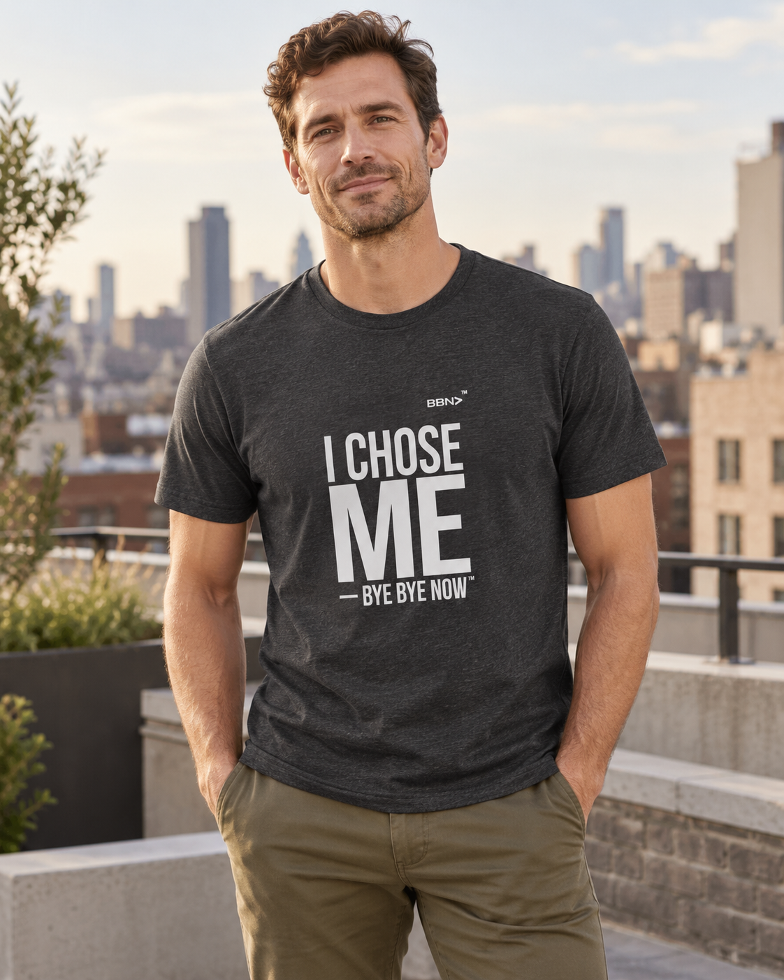 AI styling concept: Man outdoors wearing a dark gray heather T-shirt with bold white “I Chose Me” lettering and white “Bye Bye Now”.