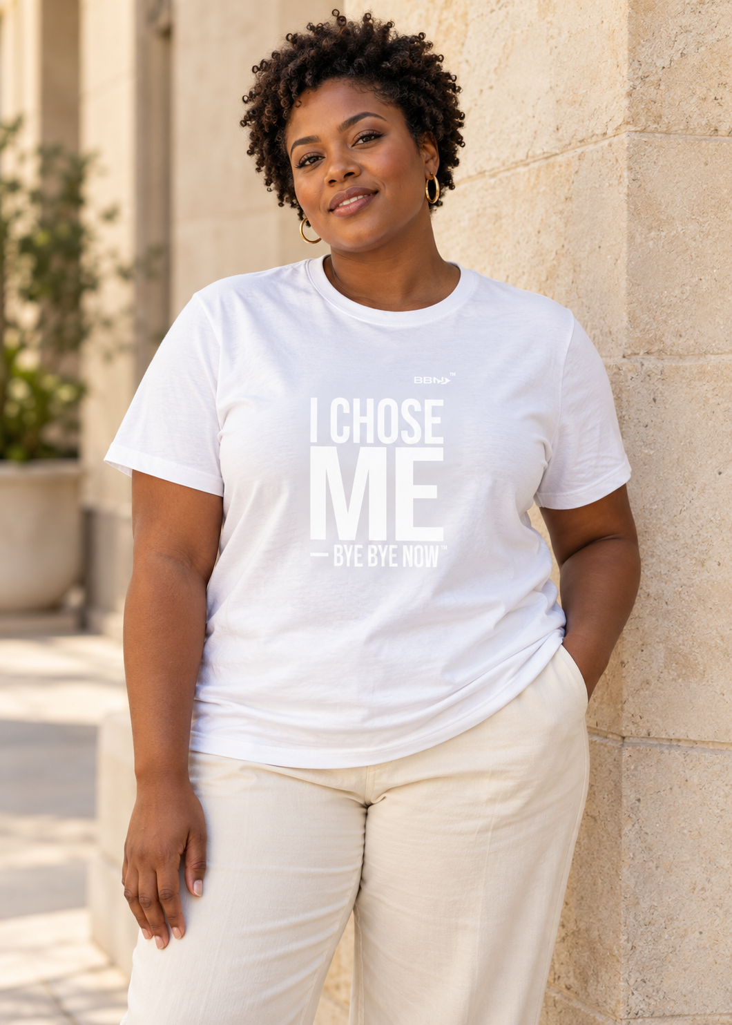 AI styling concept: Woman outdoors wearing a white T-shirt with bold white “I Chose Me” lettering and white “Bye Bye Now”.