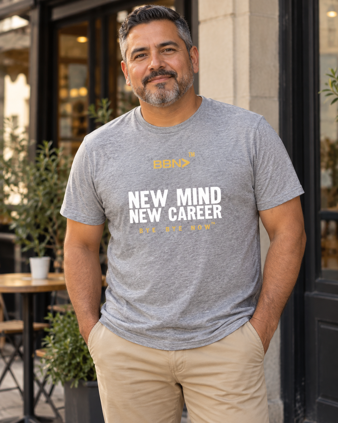 AI styling concept: Man outdoors wearing an athletic heather gray T-shirt with white “New Mind New Career” lettering and a gold BBN logo.